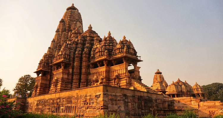 Ornately carved sandstone temple of Khajuraho glowing in warm evening light.