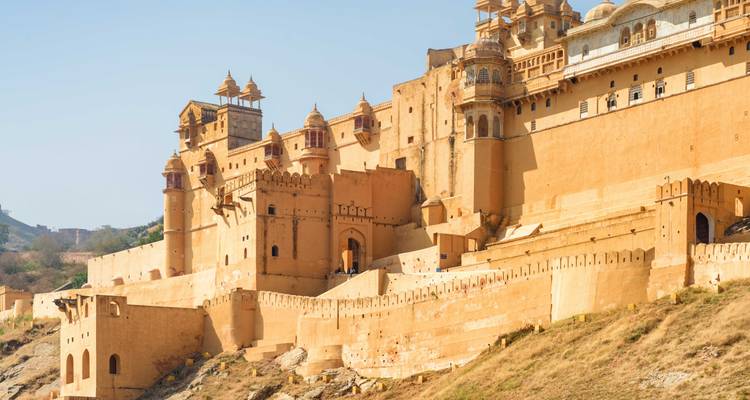 Massive ochre ramparts and domed towers of Amber Fort rising above rocky hills.