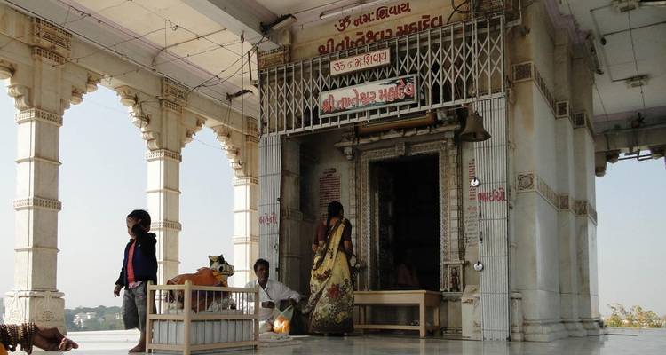 Tempelingang met tekst erboven, mensen zichtbaar.