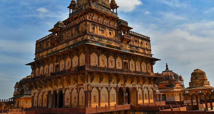 Orchha Fort met ingewikkelde architectuur tegen een blauwe hemel.
