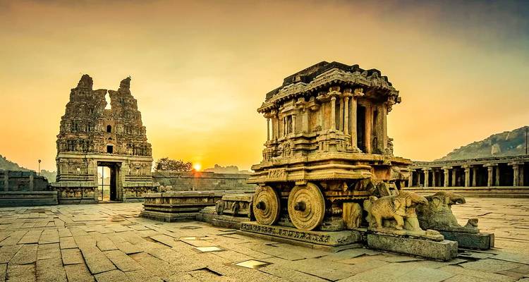 Ancient stone chariot and temple with sunrise.