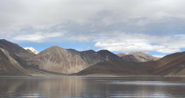 Klarer See mit Bergen und Wolken