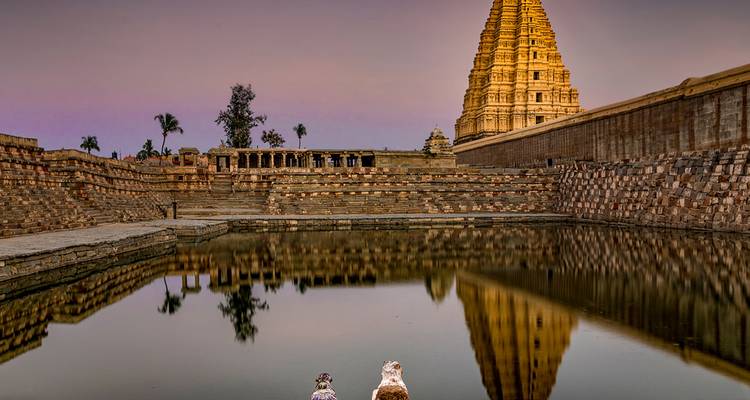 Ein großer Tempel mit seiner Spiegelung in einem Wasserbecken bei Sonnenuntergang.