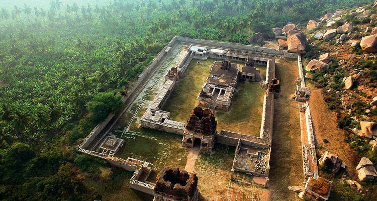 Luftaufnahme eines antiken Tempelkomplexes inmitten einer grünen Landschaft.