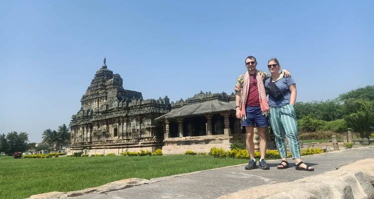 Dos personas frente a un templo antiguo.