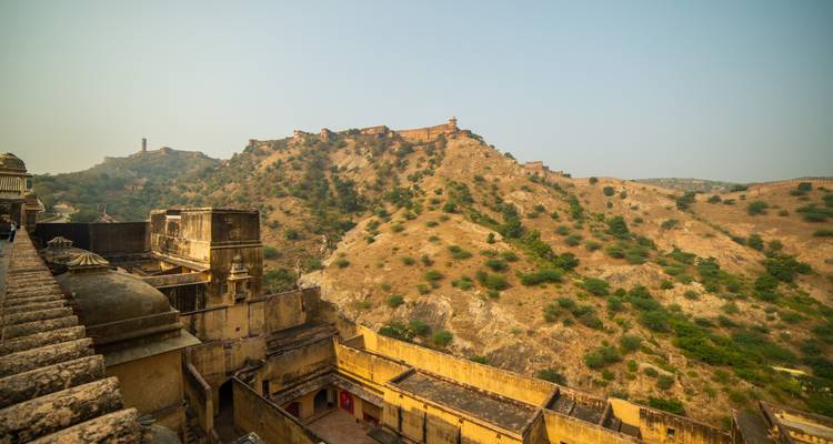 Hilly landscape with distant fort and buildings.