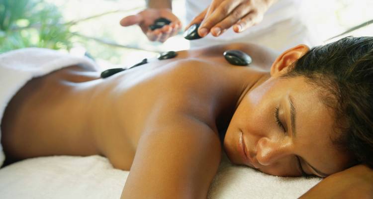 Eine Frau, die eine Heißsteinmassage in einer ruhigen Umgebung erhält.