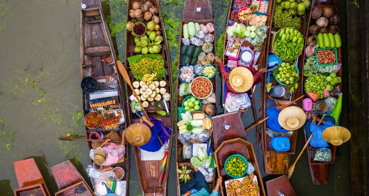 Vue de dessus de bateaux de marché flottant vibrants chargés de produits tropicaux.