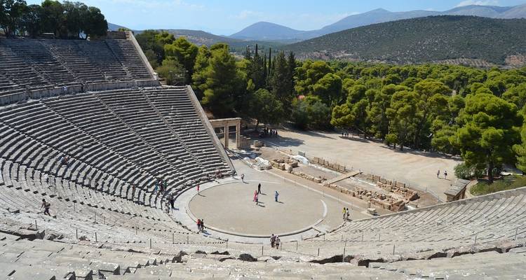 Amphithéâtre antique avec des touristes qui explorent.