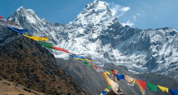 Banderas de oración frente a una majestuosa montaña nevada.