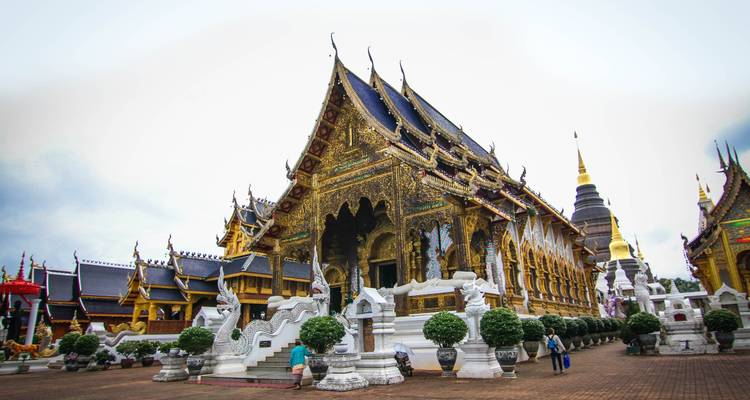 Lavishly decorated northern Thai temple complex with white guardian lions.