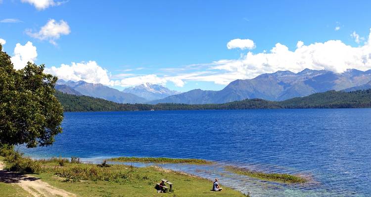 Picknick bij Rara Lake in Nepal met een bergachtige achtergrond.