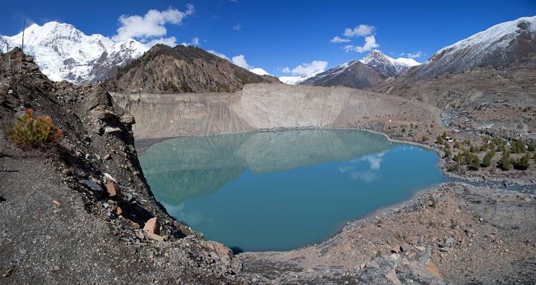 Bergmeer dat besneeuwde toppen weerkaatst in Nepal.