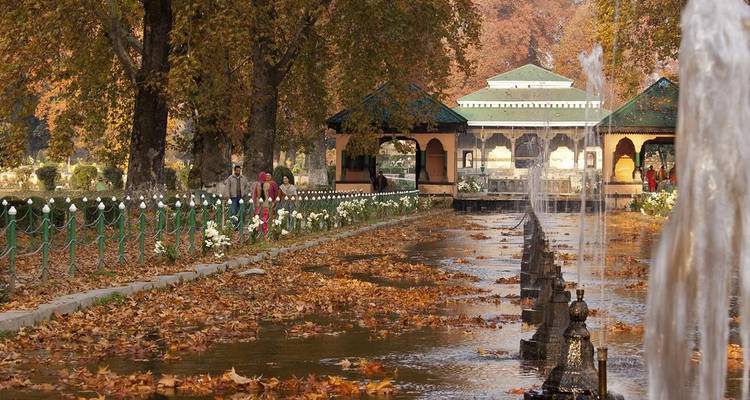 Prunkvoller Garten mit Springbrunnen und historischer Architektur.