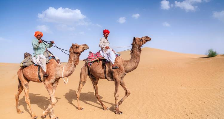 Deux hommes montant des chameaux dans le désert.