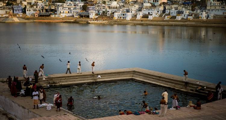 Groupe de personnes à un ghat de baignade au bord d'un lac.