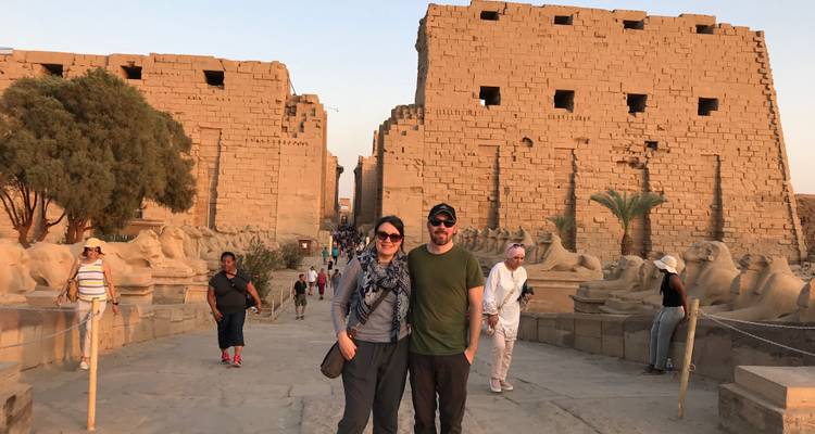 Twee toeristen in een tempelcomplex met sfinxbeelden.