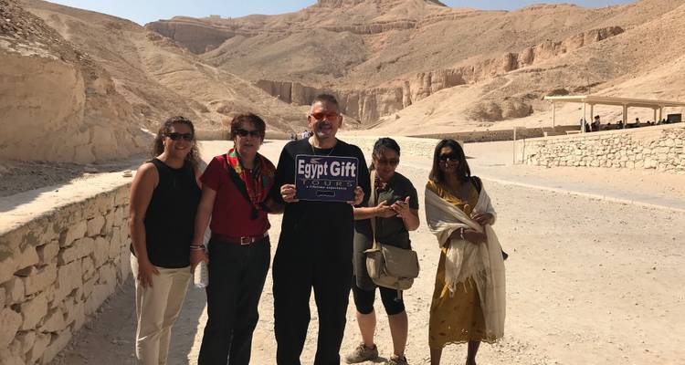 Groep toeristen met een tourbord in een woestijnlandschap.