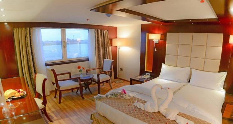 Een binnenaanzicht van een luxueuze hotelkamer met een bed en uitzicht op de rivier.