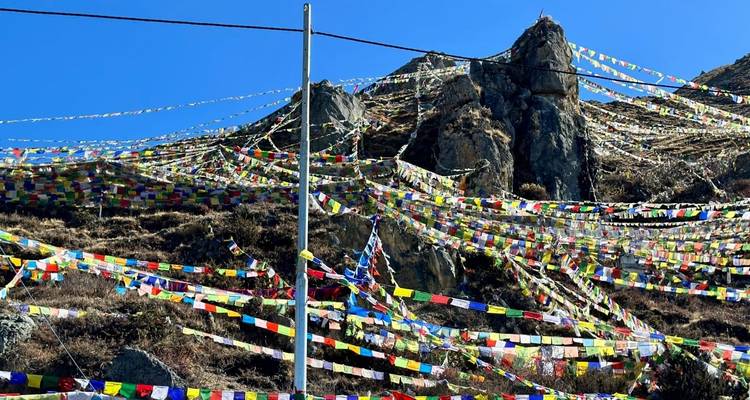 Colourful prayer flags on a rocky hill.