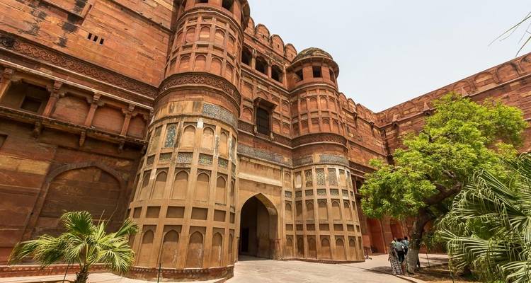Historische Festung mit gewölbtem Eingang und Touristen in Agra.