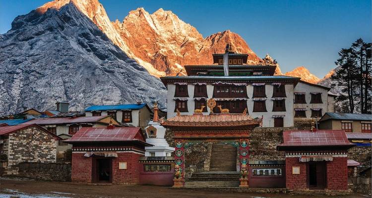 Buddhistisches Kloster mit majestätischen Bergen bei Sonnenuntergang.