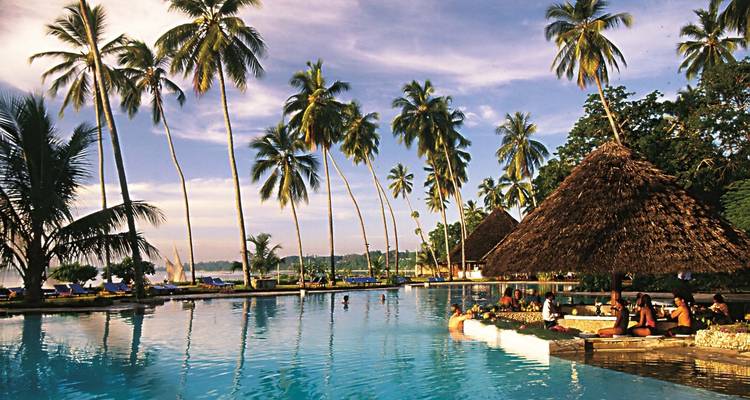 Resort view with palm trees and pool in Zanzibar.