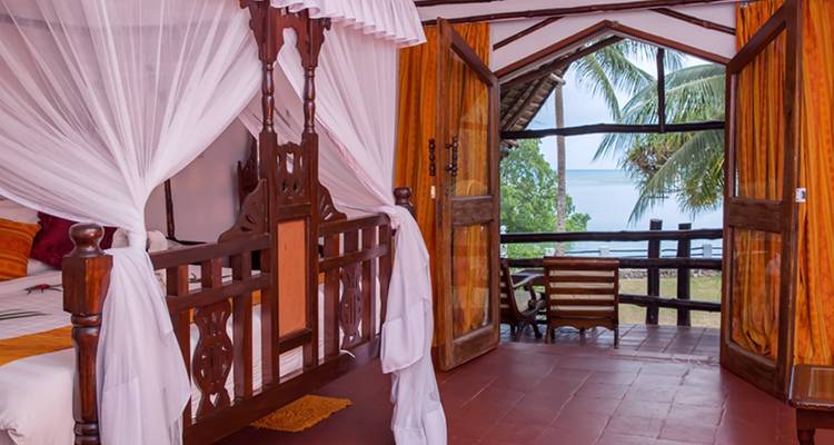 Bedroom with a view of the ocean through the windows.
