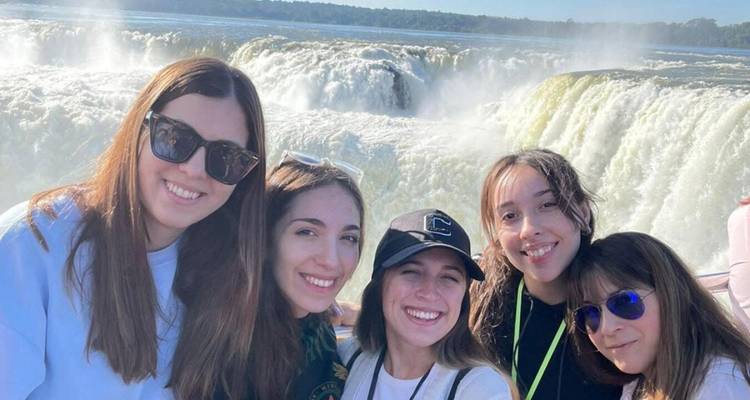 A group of women posing in front of Iguazu Falls.