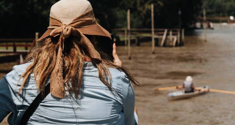 Femme prenant une photo au bord de l'eau avec activité d'aviron.