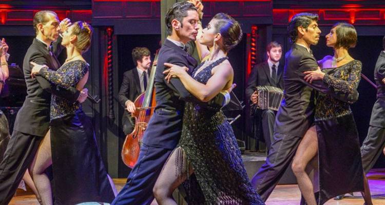 Des personnes qui dansent dans un spectacle de tango avec des musiciens.