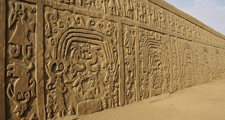 Uitgesneden reliëf met antieke motieven op een adobe muur.