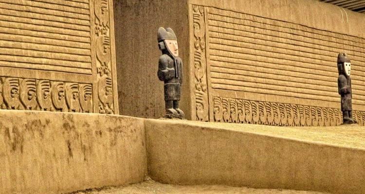 Ancient wall with traditional patterns and statues standing guard.