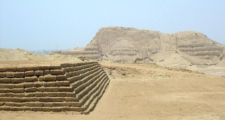 Desert landscape with ancient pyramid structures.