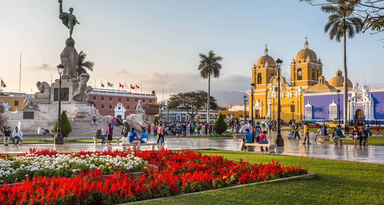 Plaza with people, flowers, and a church.