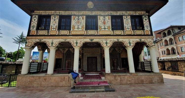 Bâtiment historique décoré avec des motifs complexes et une personne sur les marches.