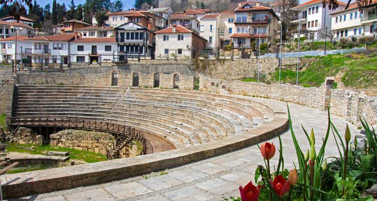 Amphithéâtre antique avec des fleurs au premier plan.
