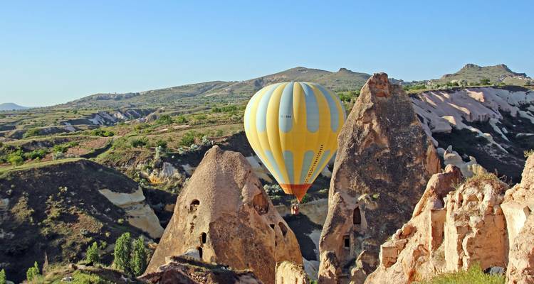 Heteluchtballon boven rotsachtig Cappadocië landschap.