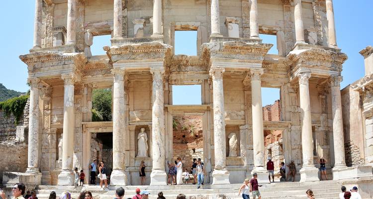 Drukke oude ruïnes met grootse zuilen en beelden.