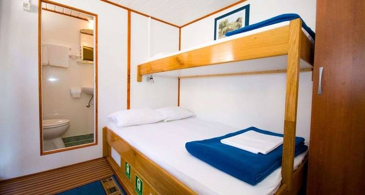 Innenraum einer kleinen Hütte mit Etagenbetten und Badezimmer.