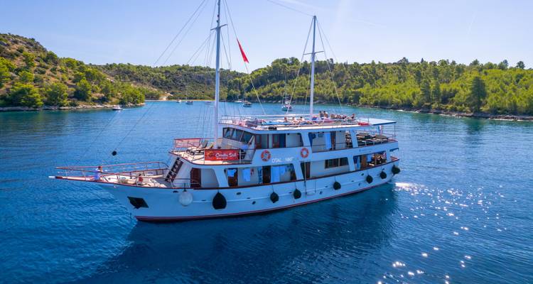 Klassische Yacht auf ruhigen blauen Gewässern nahe der Küste.