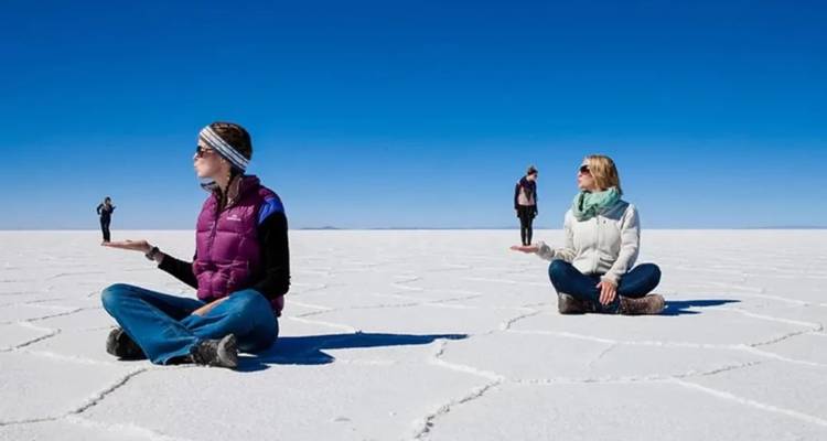 Personas jugando con la escala en el famoso salar.