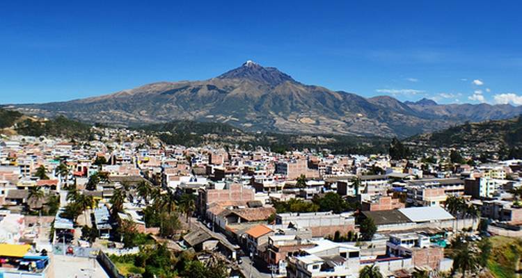 Luftaufnahme einer Stadt mit einem Berg im Hintergrund.