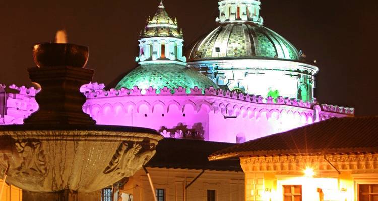 Beleuchtete Kuppel und Gebäude bei Nacht in Quito.