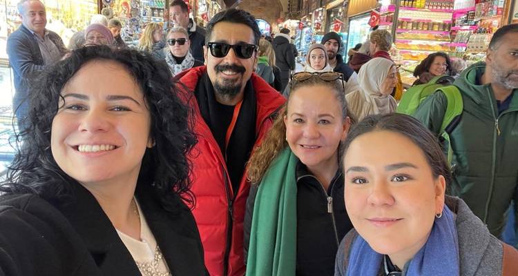 Gruppenselfie auf einem belebten Markt.