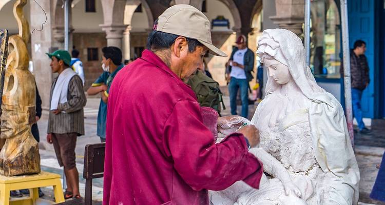 Kunstenaar die aan een standbeeld werkt in een open gebied.