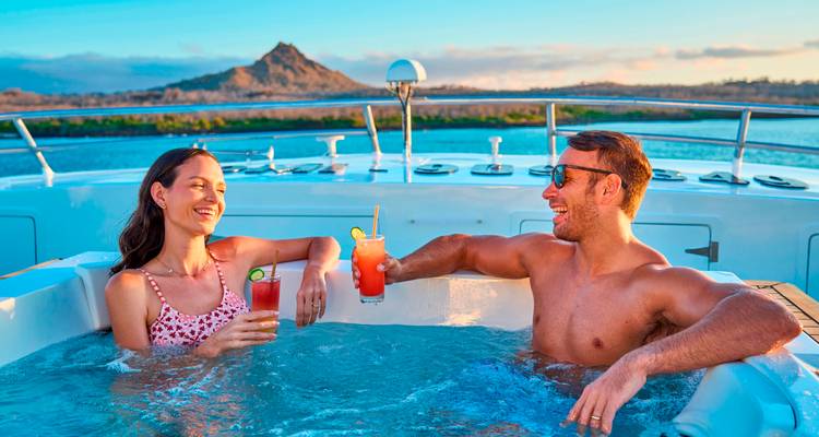Couple profitant d'un jacuzzi avec vue sur le coucher de soleil sur un yacht.