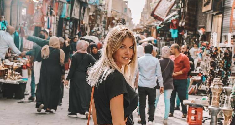 Frau in einer belebten Marktstraße.