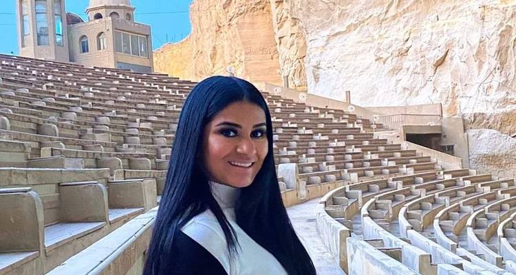 Frau in einem Amphitheater mit felsiger Umgebung.