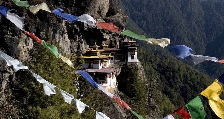 Fernblick auf ein berühmtes Kloster auf einer Klippe, umgeben von Gebetsfahnen.